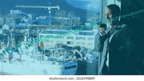 Image of data processing over caucasian businessman talking on smartphone. Global business, computing and digital interface concept digitally generated image.