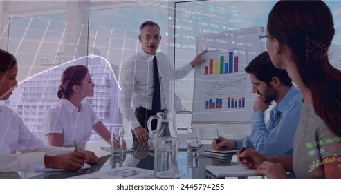 Image of data processing over diverse business people at meeting. global business and digital interface concept digitally generated image.