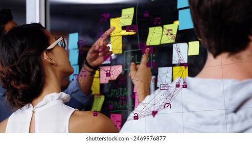 Image of data processing over diverse business people taking notes on glass wall. Global business and digital interface concept digitally generated image.