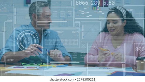 Image of data processing over diverse colleagues working in office. Global business, computing and digital interface concept digitally generated image.