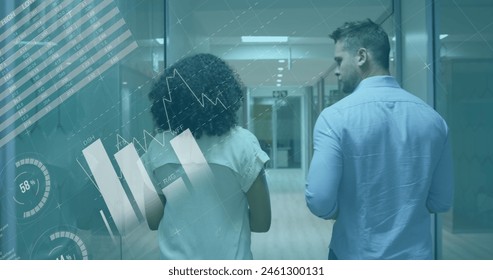 Image of data processing over rear view of diverse man and woman discussing at office corridor. Computer interface and business data technology concept - Powered by Shutterstock