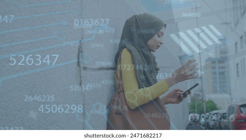 Image of data processing ovr biracial woman in hijab using smartphone drinking coffee on street. Global economy and business data technology concept - Powered by Shutterstock