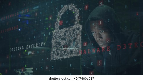 Image of data processing and shield with padlock over african american male hacker using laptop. cloud computing and data processing concept digitally generated image.