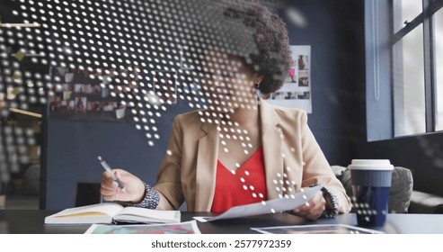 Image of data processing, world map over biracial businesswoman having image call in office. Global business and digital interface concept digitally generated image.