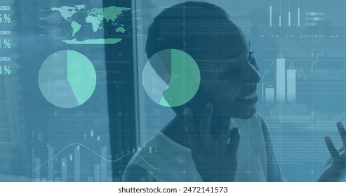 Image of data processsing over happy african american woman talking on smartphone at office. Computer interface and business data technology concept