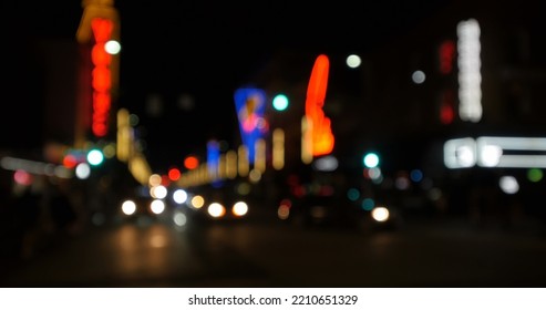 Image Of Defocussed Shopfront Lights With Street Lighting And Traffic On A City Road At Night. City Life, Nightlife, Electricity And Travel Concept.