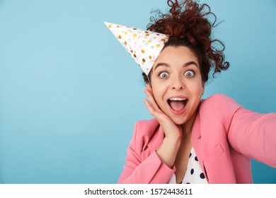 Image Of Delighted Caucasian Woman In Party Cone Taking Selfie Photo And Smiling Isolated Over Blue Background