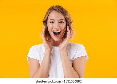 Image of delighted woman in basic t-shirt smiling at camera isolated over yellow background
