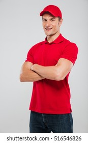 Image of deliveryman with arms crossed. in studio. looking at the camera. isolated gray background