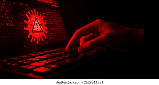 The image depicts a redlit scene of cyber threat. A hand types on a keyboard. The screen shows binary code and a virus warning, all bathed in red light.