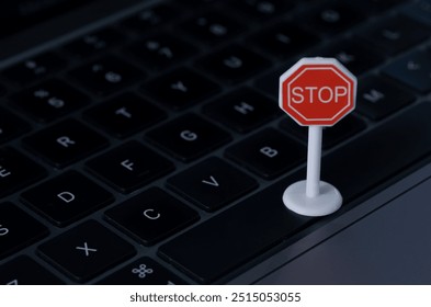 The image depicts a stop sign placed on a laptop keyboard, symbolizing the need to pause or halt online activity. - Powered by Shutterstock