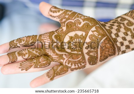 Image detail of henna being applied to hand.