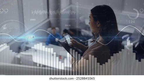 Image of diagrams and data processing over biracial businesswoman using smartphone. Global business, technology and digital interface concept digitally generated image.
