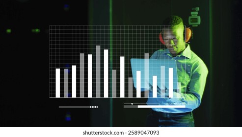 Image of digital data processing over afrcian american it man with laptop by computer servers. Global connections, computing and data processing concept digitally generated image.