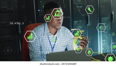 Image of digital icons on african american male engineer holding a network cable at server room. Computer interface and business data storage technology concept