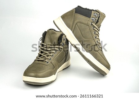 Image displays olive green casual sneakers with a blend of canvastextile uppers and synthetic overlays, low-top profile, lace closures, metal eyelets, textured soles for grip, white accents on lower