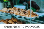 The image displays a variety of pastries arranged on a glass display case, showcasing their delicious textures and colors.