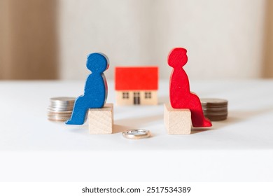 Image of divorce, divorcing couples, separating partners. Miniature of couple, wedding ring and house.
