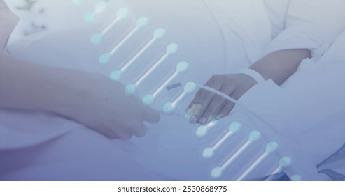 Image of dna strand over biracial female patient in hospital bed and caucasian doctor treating. Medicine, health and digital interface concept, digitally generated image. - Powered by Shutterstock