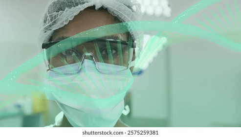 Image of dna strand rotating over portrait of african american female surgeon in theatre. Surgery, digital interface, connection, hospital and healthcare, digitally generated image.