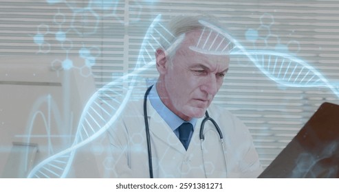 Image of dna strands with data processing over caucasian male doctor reading x-ray scan. Global medicine, healthcare, science and digital interface concept digitally generated image.