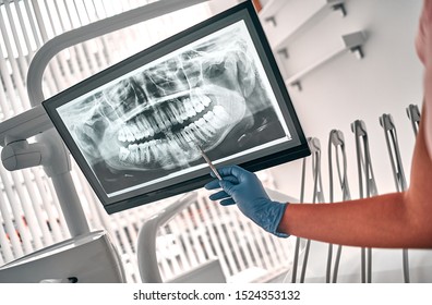 Image of doctor or dentist presenting with tooth x-ray film recommend patient in the treatment of dental and dentistry, working at workplace.