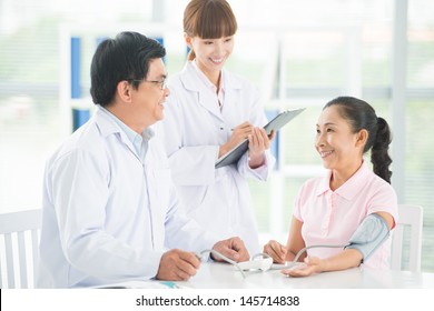 Image Of A Doctor And His Nurse Checking Up A Senior Patient In The Clinic