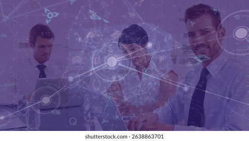 Image of dots and programming language over caucasian coworkers working over laptop. Digital composite, multiple exposure, coding, communication, business, teamwork and technology concept.