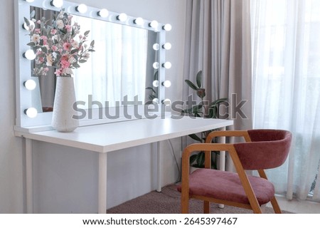 Image of a dressing table with a mirror framed with light bulbs around it in a bedroom, empty table, with copy space.