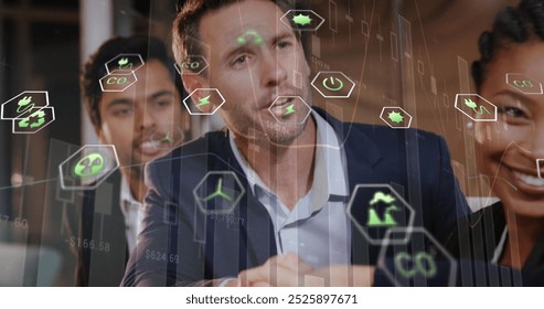 Image of eco icons and data processing over diverse business people in office. Global business, computing, digital interface and data processing concept digitally generated image.