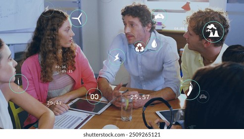 Image of ecology icons over diverse colleagues at meeting in office. Business, technology and digital interface concept digitally generated image. - Powered by Shutterstock