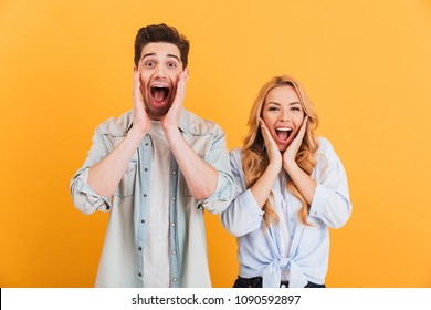 Image of ecstatic people man and woman in basic clothing screaming in surprise or delight and touching cheeks isolated over yellow background - Shutterstock ID 1090592897