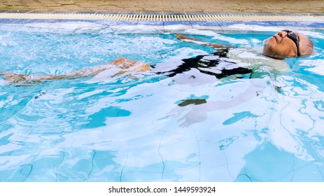 Image Of An Elderly Man Looks Relaxed While Floating In The Swimming Pool