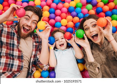 Image of emotional little child have fun with his parents in entertainment game center. Looking camera.