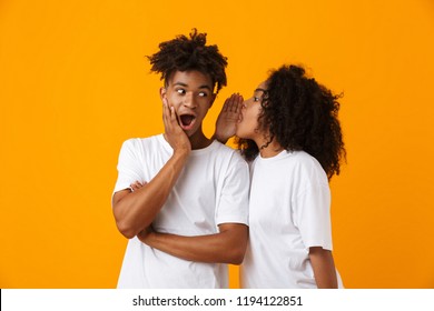 Image of emotional young cute african couple posing isolated over yellow background gossiping tell secret. - Shutterstock ID 1194122851