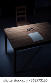 Image Of Empty Desk With Handcuffs In Interrogation Room