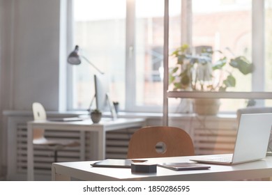 Image of empty modern office with desk with laptop