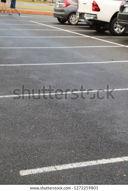 Image of empty\
parking spaces on asphalt ground of parking area after raining in\
the evening. Vertical\
view.