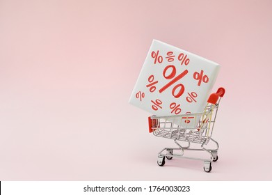 Image of empty shopping trolley or cart with box of discount percent sale black Friday products on pink background. Concept of sell or buy with place for your text - Shutterstock ID 1764003023