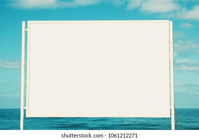 Image Of Empty White Billboard On The Beach Infront Of Blue Sea And The Sky. For Mockup And Advertisement