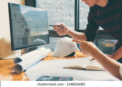 Image of engineer or architect partner meeting for working with architectural project, drawing and sketching for inspection architectural project on blueprint at workspace.