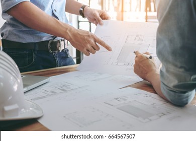 Image of engineer or architectural project, Close up of Architects engineer's hands drawing plan on BluePrint and discussing to partner with Engineering tools on workplace, Construction concept .