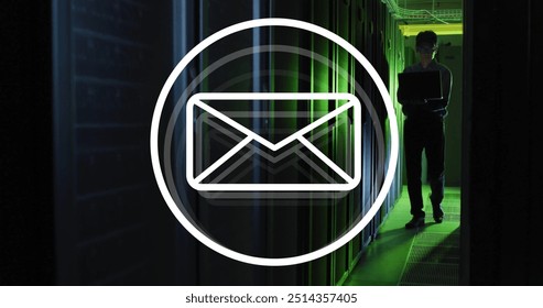 Image of envelope email icon over male technician with laptop in dark computer server room. Data, digital interface, connection and communication, digitally generated image.