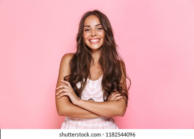 Image of european lovely woman 20s with long hair wearing dress smiling at you with arms crossed isolated over pink background