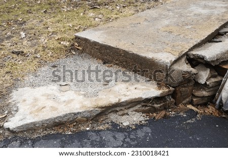 Image example showing the effects of time on an old weathered concrete walkway and step section. The worn-out area shows years of accumulated damage in need of repairs and maintenance attention. 