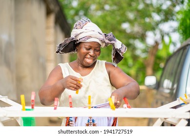 Image Of Excited African Woman, Holding Clothes Peg- Outdoor Cloth Drying Concept