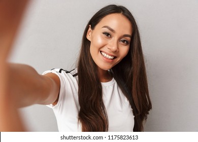 Image of excited happy young woman isolated over grey background make selfie by camera. - Shutterstock ID 1175823613
