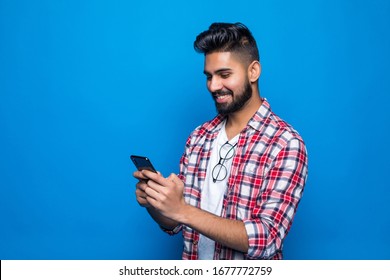 Image Of Excited Young Happy Bearded Man Posing Isolated Over Blue Wall Background Using Mobile Phone Chatting.