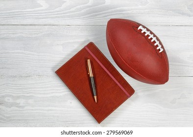 Image Of Executive Notepad, Pen And American Football On White Rustic Wood. Playbook Concept For Game Plan.