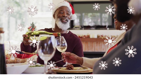 Image of falling snow over african american senior couple deinking wine. International day of older persons concept digitally generated image. - Powered by Shutterstock